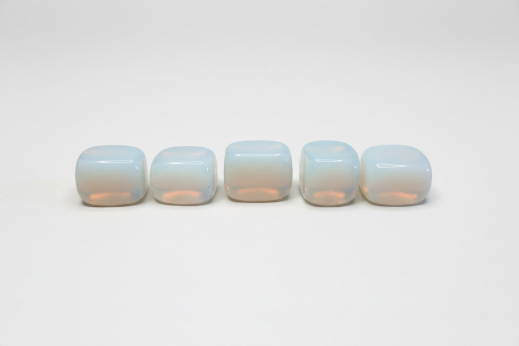 Five white rounded but cubed  opalite on a white background