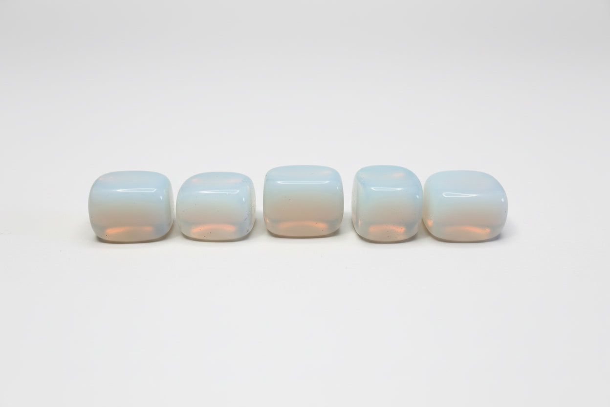 Five white rounded but cubed  opalite on a white background